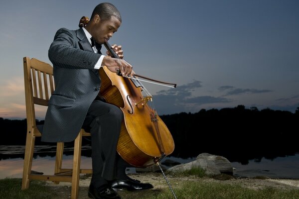 Homem com violoncelo na natureza