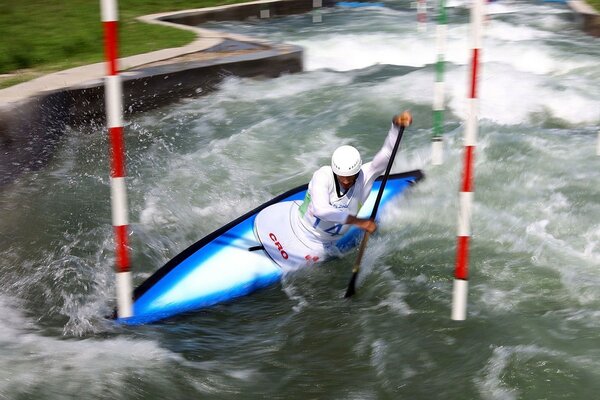 A single swimmer rafting on a canoe at the moment of passing a raging turn of the river