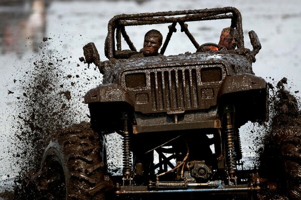 Dos hombres montando un Jeep futurista en el barro