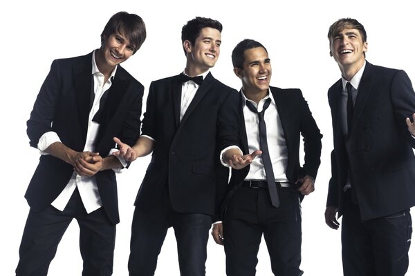 Four guys smiling in suits