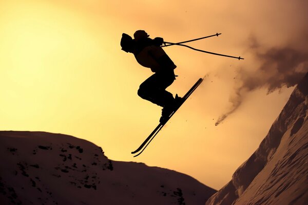 Silhouette of a skier jumping at sunset