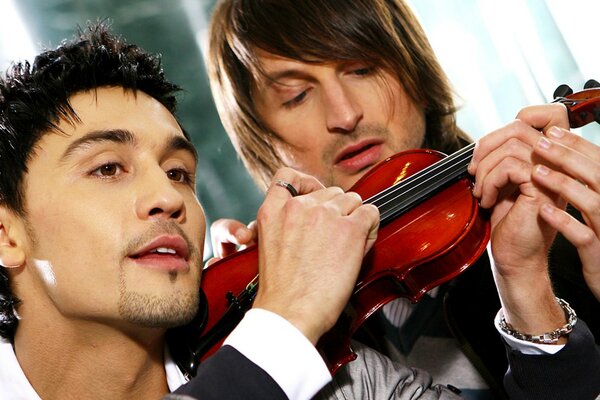 Two men hold a violin