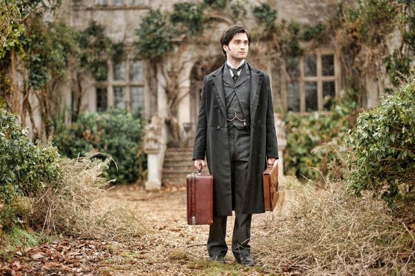 Homme dans des vêtements Vintage avec des valises