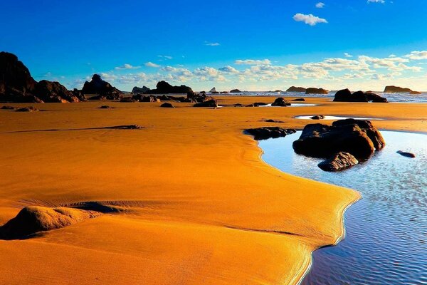 Água na areia e céu nublado