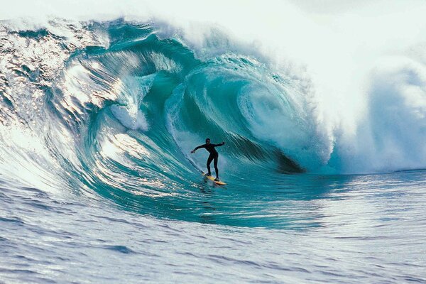 Mesmerizing turquoise ocean wave envelops the surfer