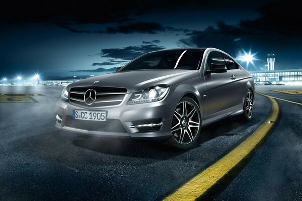 Silver Mercedes Benz in the dark on the asphalt