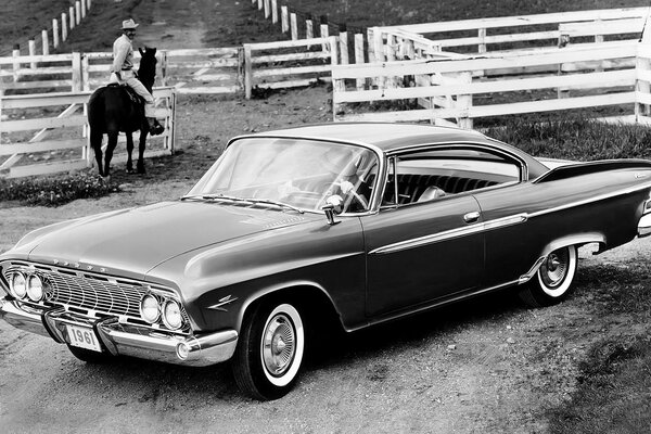 Schwarz-Weiß-Foto eines Autos der 60er Jahre auf einer Ranch