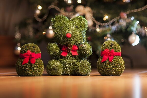 Lindos juguetes de agujas de pino adornados con arcos rosados en el fondo del árbol de Navidad