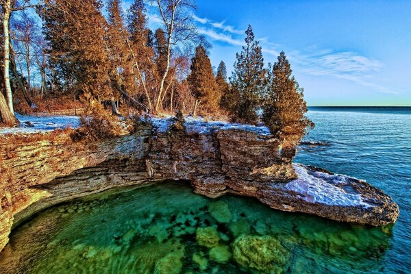 Скалистый берег озера с деревьями