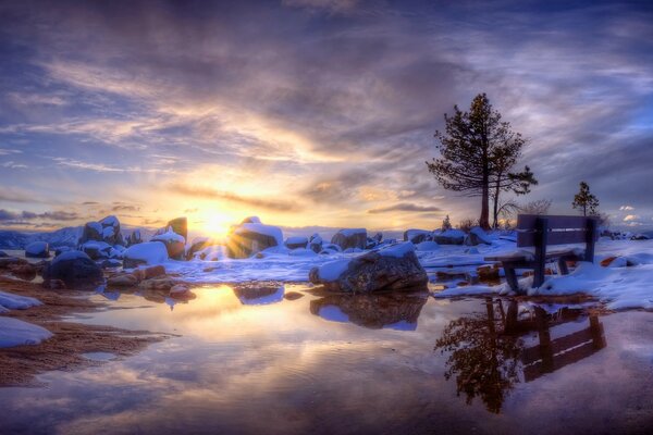 Puesta de sol de invierno con el reflejo del sol en el agua