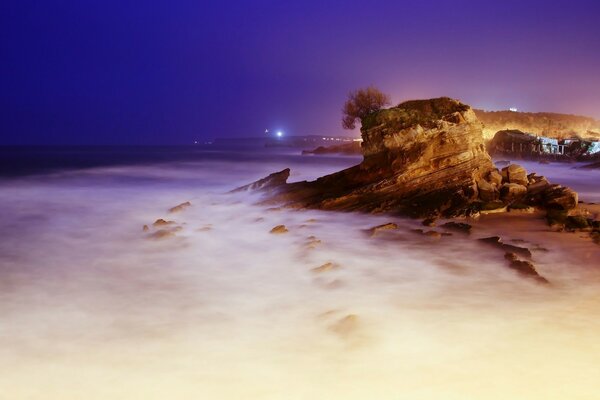 Roca en el agua por la noche