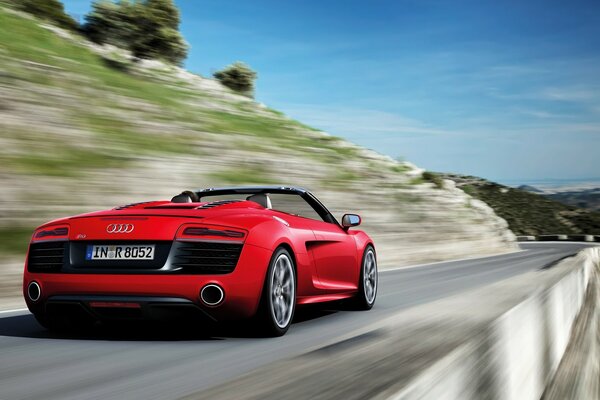 Carro esportivo vermelho em uma estrada estreita