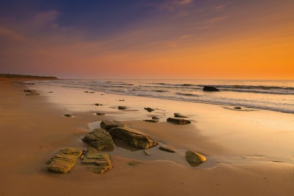 Praia da noite com pedras