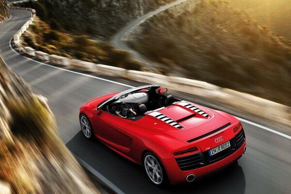 Red sports car on a narrow winding road