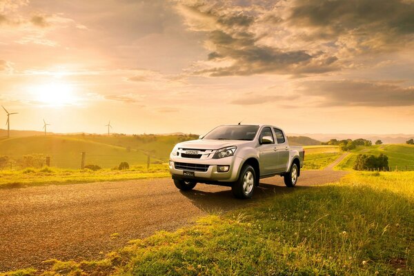 Um SUV cinzento está na estrada em um campo