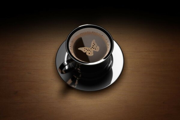 Mariposa de espuma en una taza de café