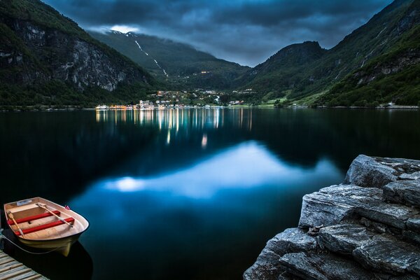 Night, boat at sea and reflections in the water