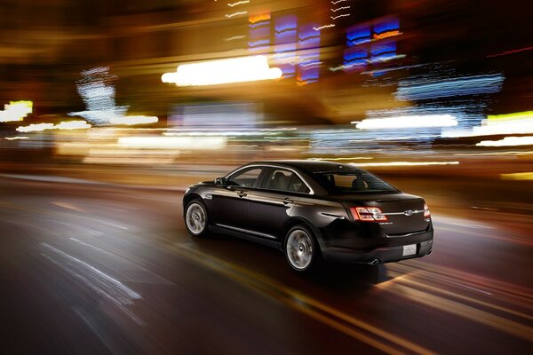 A black car is racing in lights