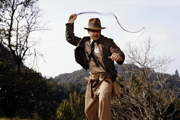 A man is beaten with a whip in a cowboy suit