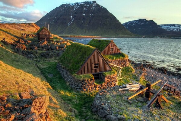 A house by the water on the background of mountains