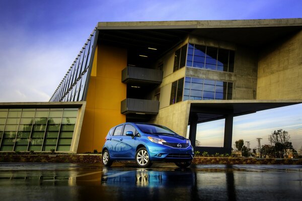 The blue color of the car on the background of the house