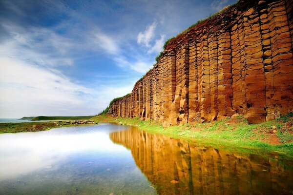 The wall stood like a shield above the water