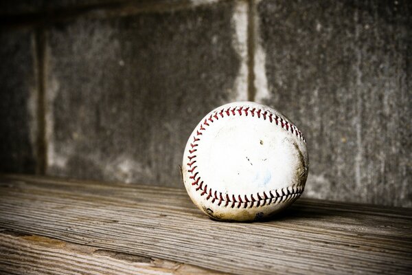 A baseball on a wooden floor