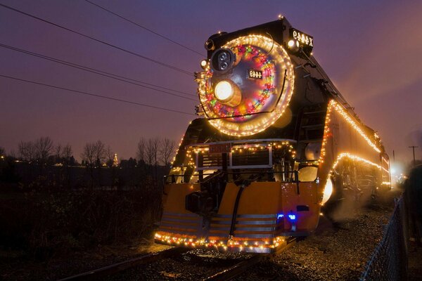 Imagen de un tren en la noche con guirnaldas