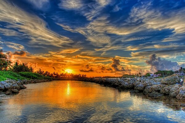 Bewölkter Himmel. Sonnenuntergang auf dem Wasser