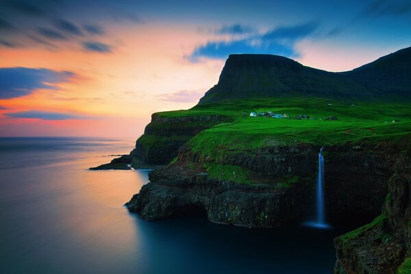 Green grass with a waterfall at sunset