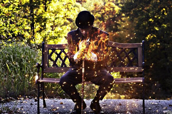 Homme assis sur un banc avec le feu dans les mains