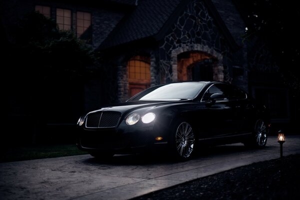 Black Bentley with bright headlights