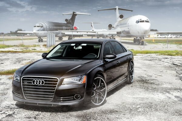 Passenger audi on the background of two planes