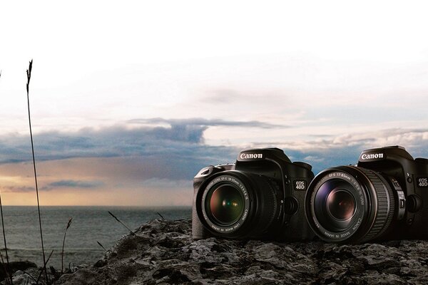 Two canon cameras with a beautiful landscape