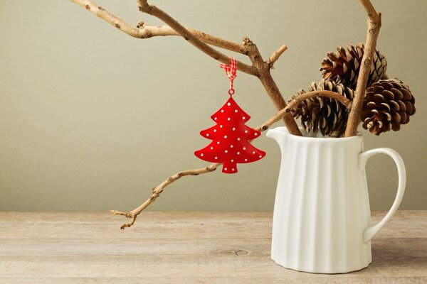 Neujahrs-Stillleben aus Tannenzapfen und Weihnachtsbaum-Schlüsselanhänger