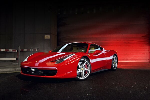 A sporty red car on the sidewalk is a little dark