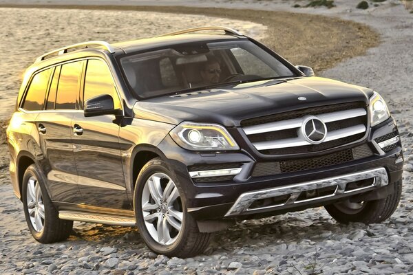 A Mercedes Benz car standing on a stone beach