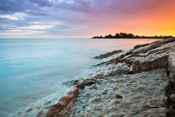 Rocky seashore with sunset on the right