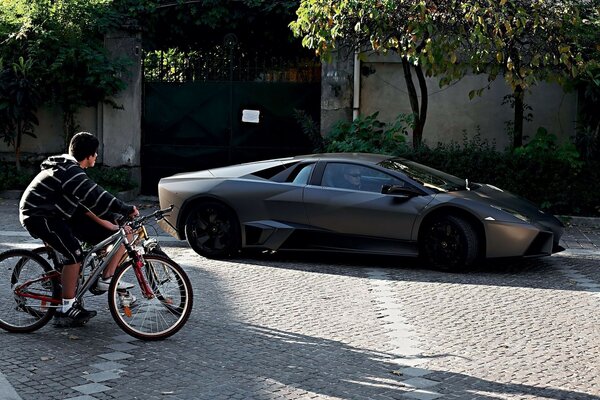 Coche deportivo y adolescente en bicicleta