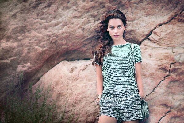 Girl on the background of a stone wall grass