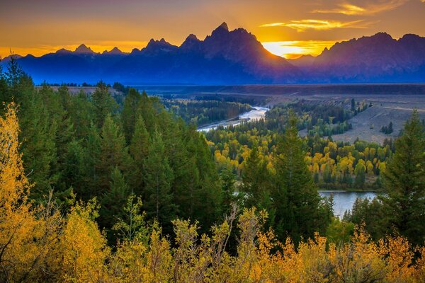 Coucher de soleil derrière la montagne au-dessus de la forêt