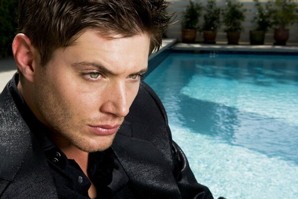 Actor with green eyes by the pool