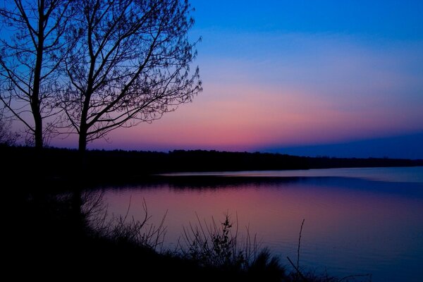 Am späten Abend am Fluss. Rosa Sonnenuntergang