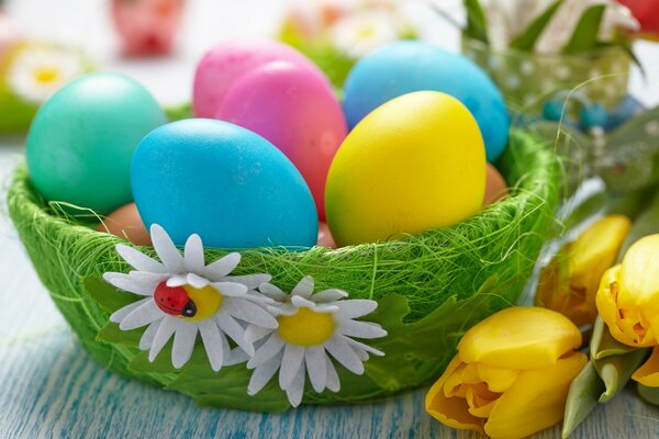 Bright colored Easter eggs. Yellow tulips