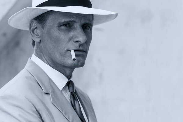 Gentleman avec une cigarette et un chapeau blanc