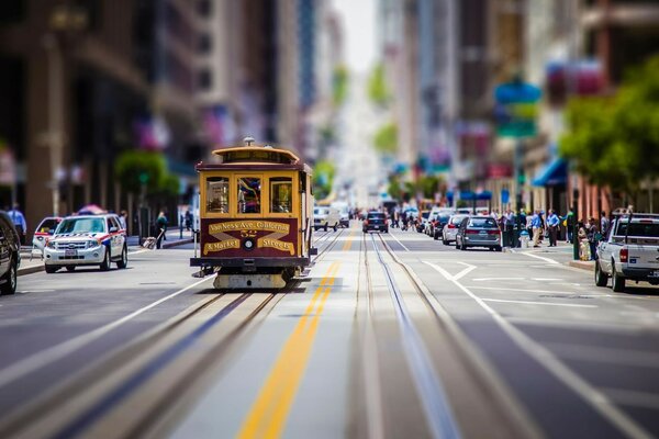 Tram rides down the street among the blurred houses