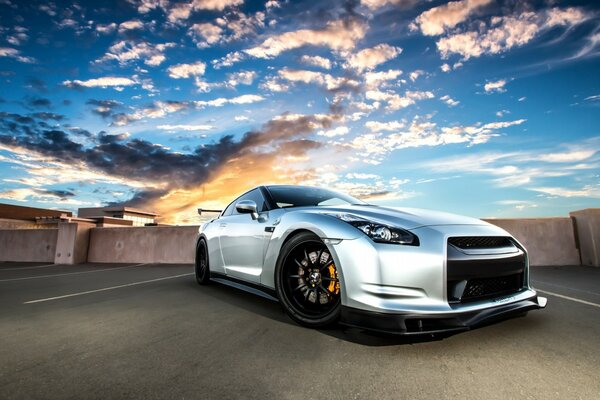 Nissan gris con un hocico depredador contra el cielo