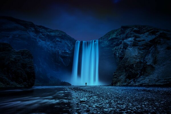 Islandia nocturna, cascada y hombre