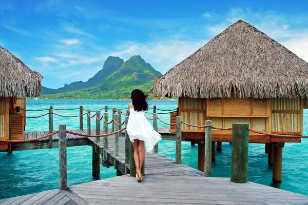 Fille en blanc sur une passerelle dans un bungalow