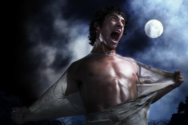 A man rips his clothes against the background of the moon